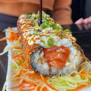 Hot roll diferenciado no formato de hot dog empanado e frito por fora, porém com recheio de salmão cru, cream cheese e cebolinha, coberto por tarê e gergelim. (Acompanha 1 sache de molho shoyo + 1 sache de tarê)