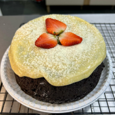 Massa de chocolate fofinha com pedaços de morangos fresco e uma cobertura cremosa de brigadeiro de leite Ninho que transborda sabor a cada fatia