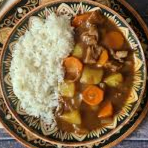 Cozido de Legumes com molho curry acompanhado de arroz e pedaços de bacon, carne bovina cortadas em cubos.