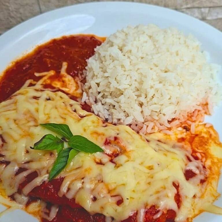 Marmita de Frango à Parmegiana 450g
Suculento filé de frango empanado, coberto com um saboroso molho de tomate caseiro e uma generosa camada de queijo derretido e gratinado. Acompanha arroz branco soltinho, formando uma refeição completa, caseira e irresistível.