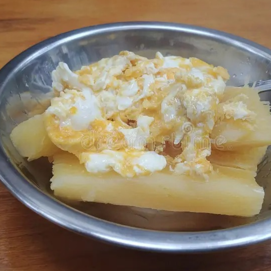 Macaxeira/Mandioca cozida com 2 ovos fritos mexidos.