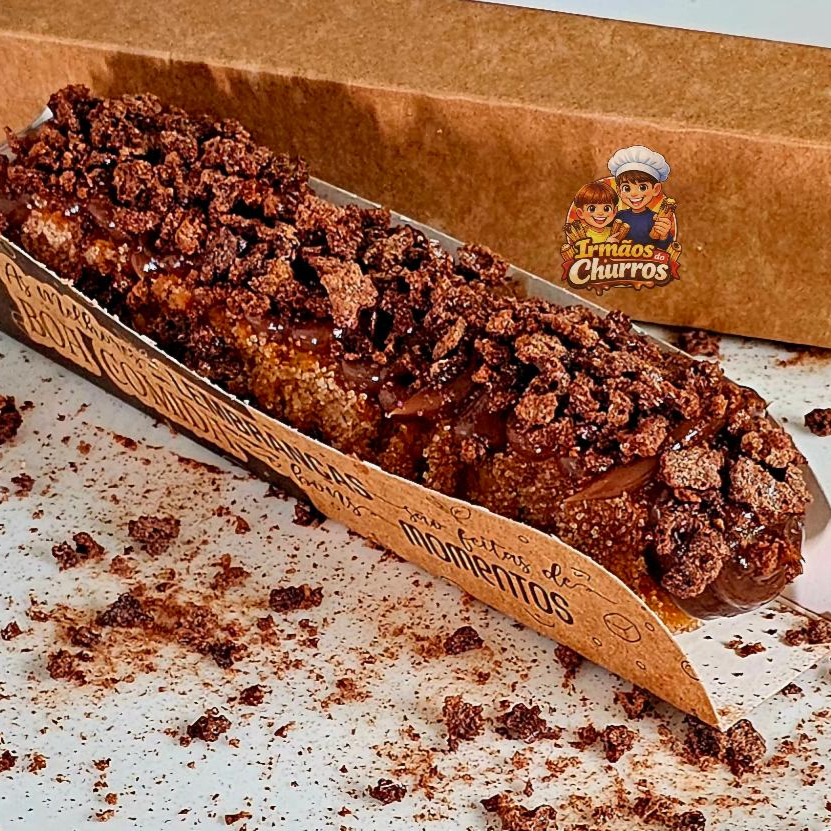 Delicioso Churros salpicado com açúcar de confeiteiro e canela em pó com recheio e cobertura de chocolate ou doce e leite coberto com Ovomaltine.