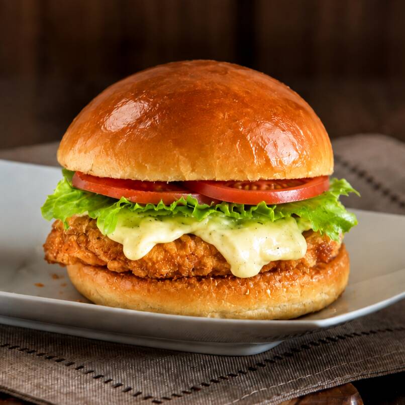 Uma tira de filé de frango empanado no ponto perfeito, queijo derretido, tomate fresco, alface crocante e pão brioche macio. Um clássico premium que entrega sabor em cada mordida.