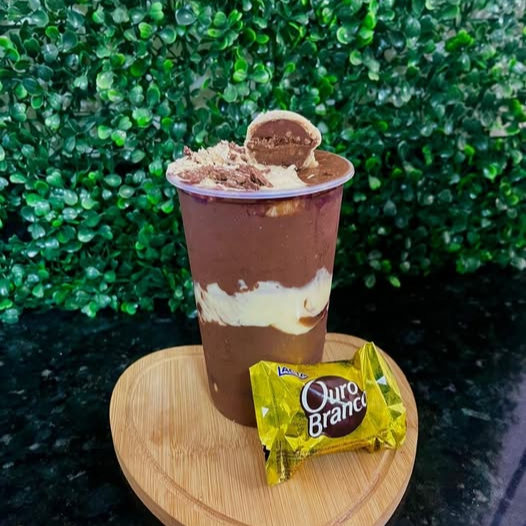 Açai temático Ouro Branco 1ª camada: Açai - 2ª camada: 1 Bombom Ouro Branco picado, creme de chocolate ao leite e creme de Ninho - 3ª camada: Açai - 4ª camada: 1 Bombom Ouro Branco picado, 1 Bombom Ouro Branco inteiro (partido ao meio) creme de chocolate ao leite e creme de Ninho.