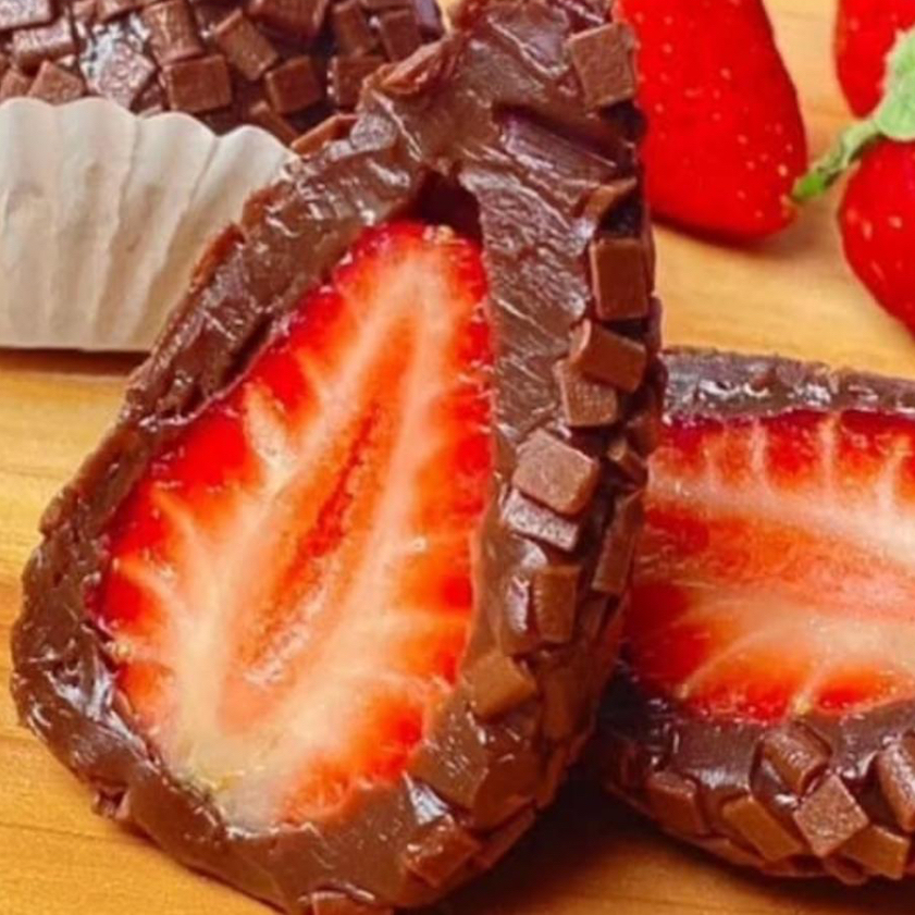 Uma delicioso massa de brigadeiro envolvendo um morango fresquinho finalizado com granule de chocolate ao leite