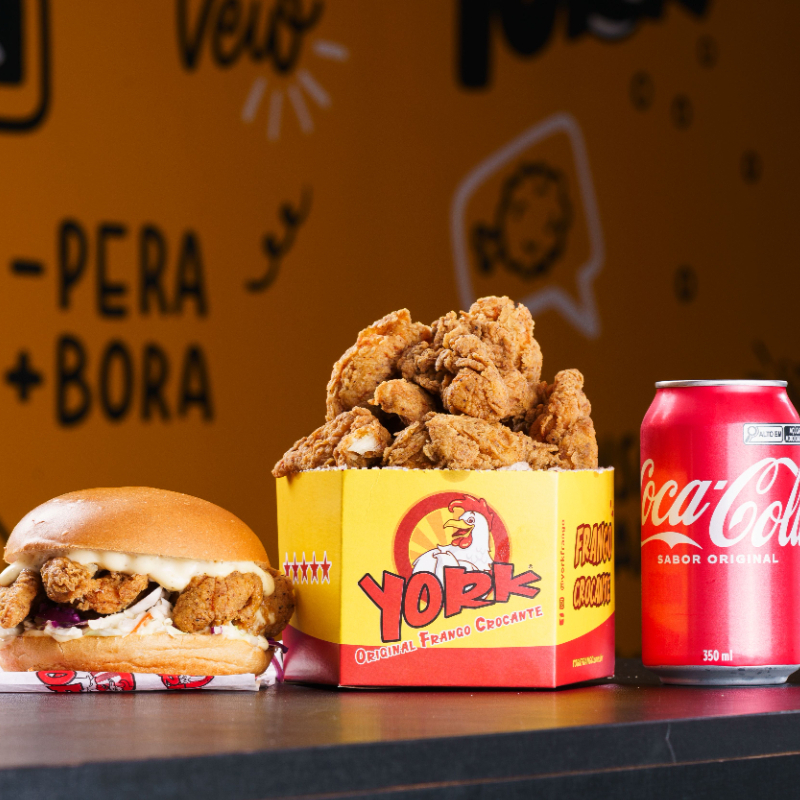 A melhor combinação com um preço incrível. 1 Lanche York Chicken Crunchy + 1 Balde Box de Frango Individual 280 gramas + 1 Refrigerante Lata 350ml. Serve 1 a 2 pessoas. Foto Ilustrativa.