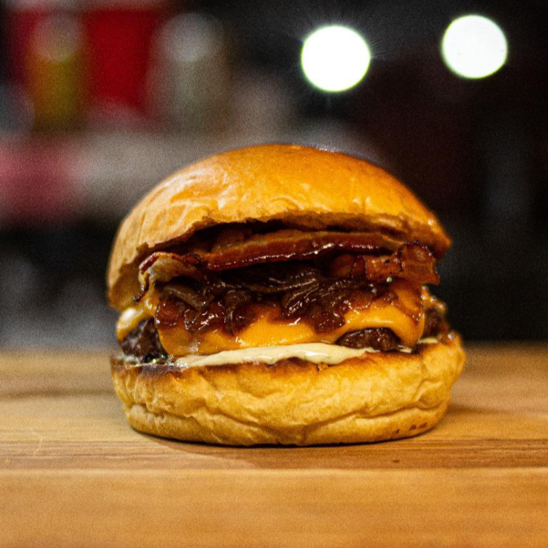Pão brioche selado na brasa, blend 120g super suculento, bacon crocante, cheddar fatiado, cebola caramelizada e barbecue.