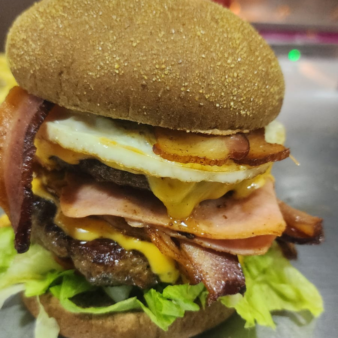 Pão Australiano, 2 Hambúrgueres Bovinos 180g, 2 Ovos, Bacon, Presunto, Queijo Prato, Salada e Maionese Gourmet