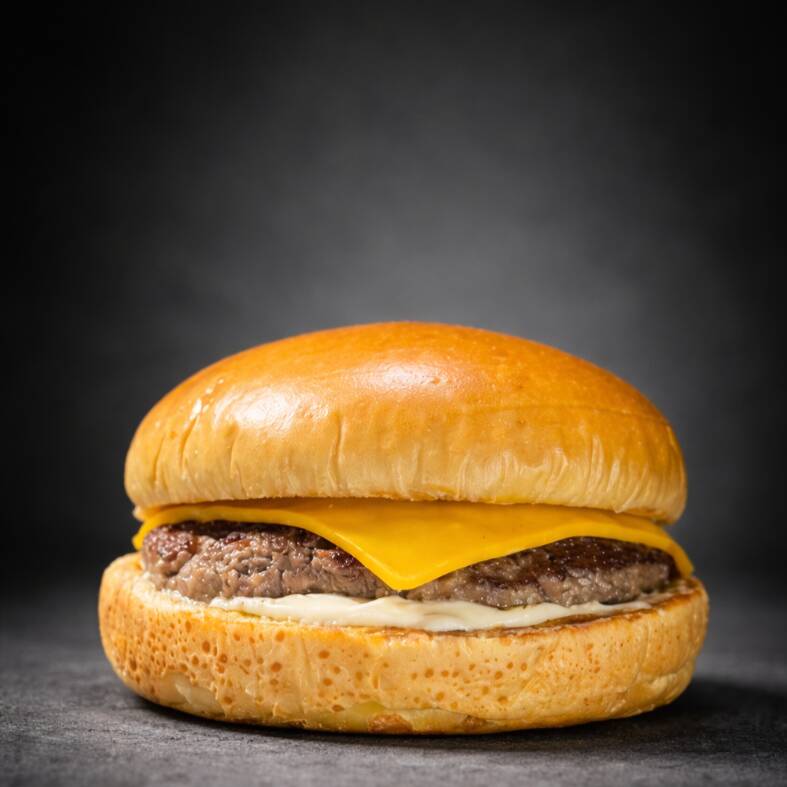 Pão de brioche macio, maionese Hellmann's, hambúrguer artesanal de 120g suculento, fatia de queijo cheddar e molho Tasty Kones.