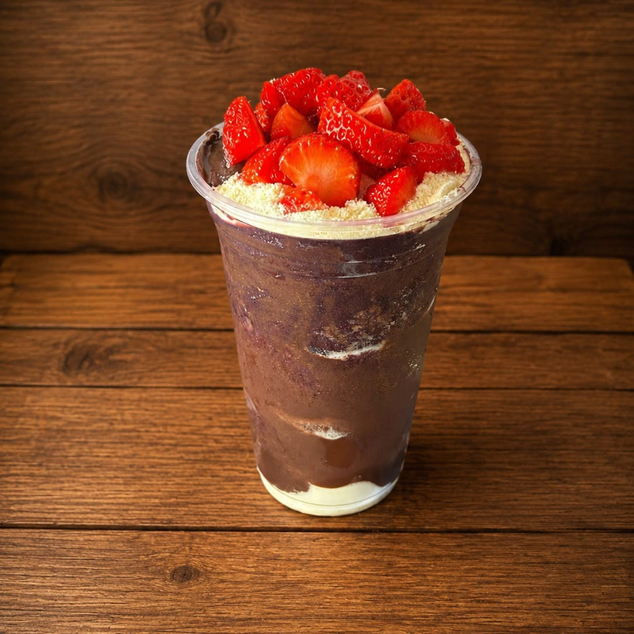 Açaí super cremoso montado em camadas de leite em pó, no topo morango e creme de avelã