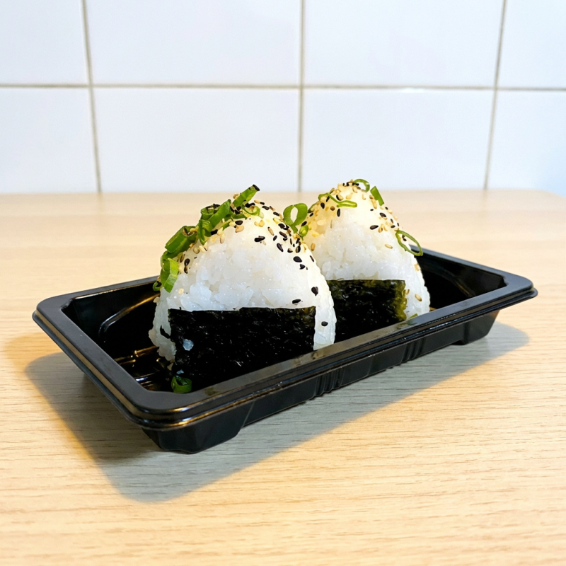 Dupla de oniguiri - o famoso bolinho de arroz japonês tradicional sobre o nori e também com cebolinha e gergelim. Acompanha molho teriyaki.