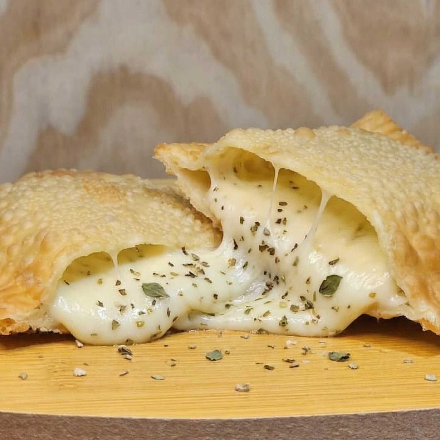 Delicioso pastel recheado com queijo mussarela derretido, um leve toque de orégano. Uma explosão de sabor!