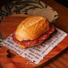 Pão francês com fatias de salame frio.