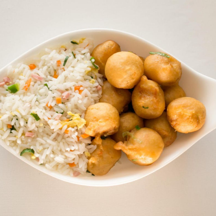 bolinho de frango empanado frito salpicado com alho e cebolinha.