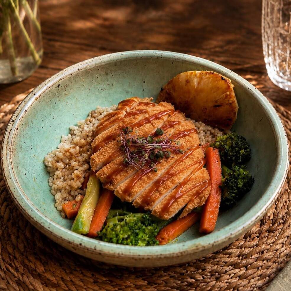 Frango empanado ao molho teriyaki, acompanhado de arroz cateto, abacaxi grelhado levemente caramelizado e legumes salteados (brócolis, cenoura e abobrinha).