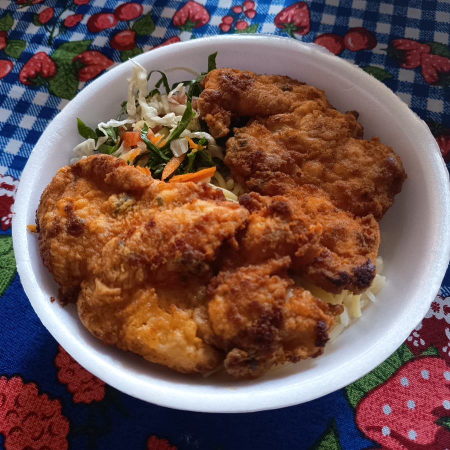 O prato é acompanhado por uma porção de arroz, feijão, macarrão, salada e farofa.