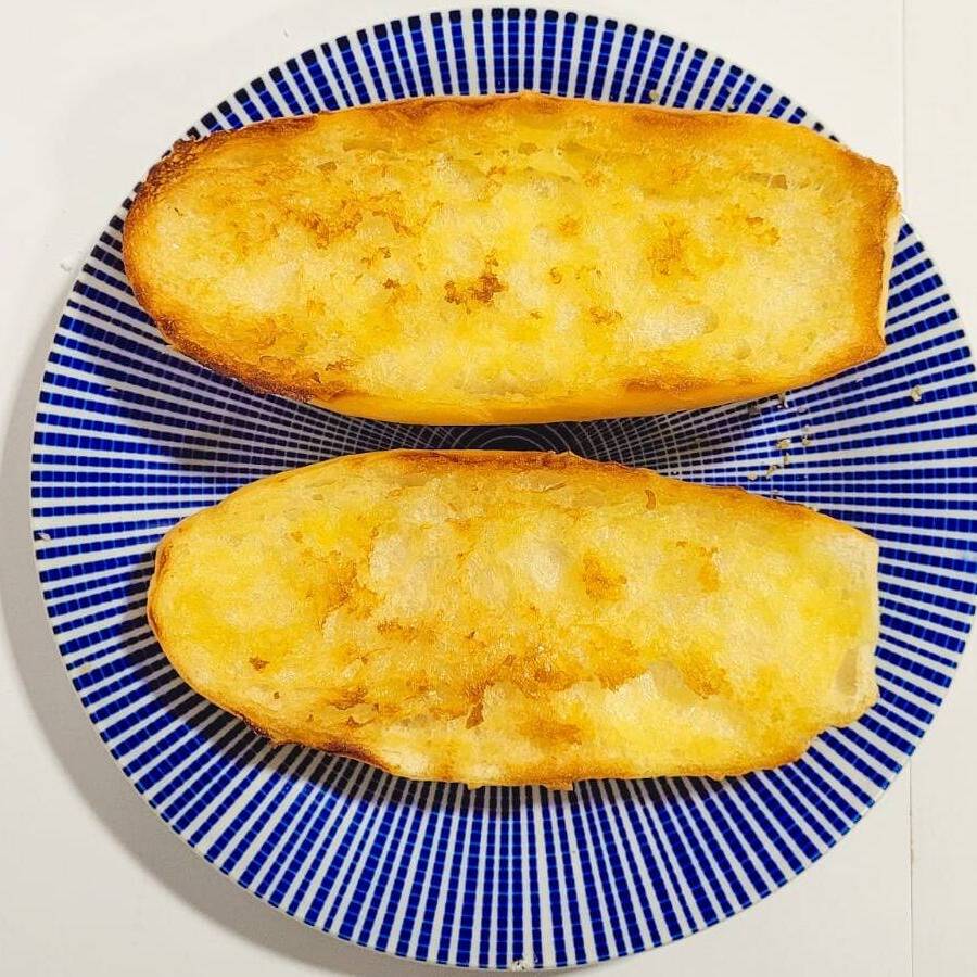 Tradicional pão francês com manteiga e finalizado na chapa.