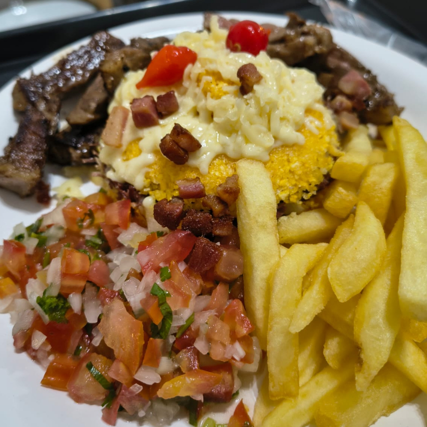 Cuscuz recheado com calabresa, coberto com mussarela derretida, acompanha vinagrete, contra filé e batata frita
