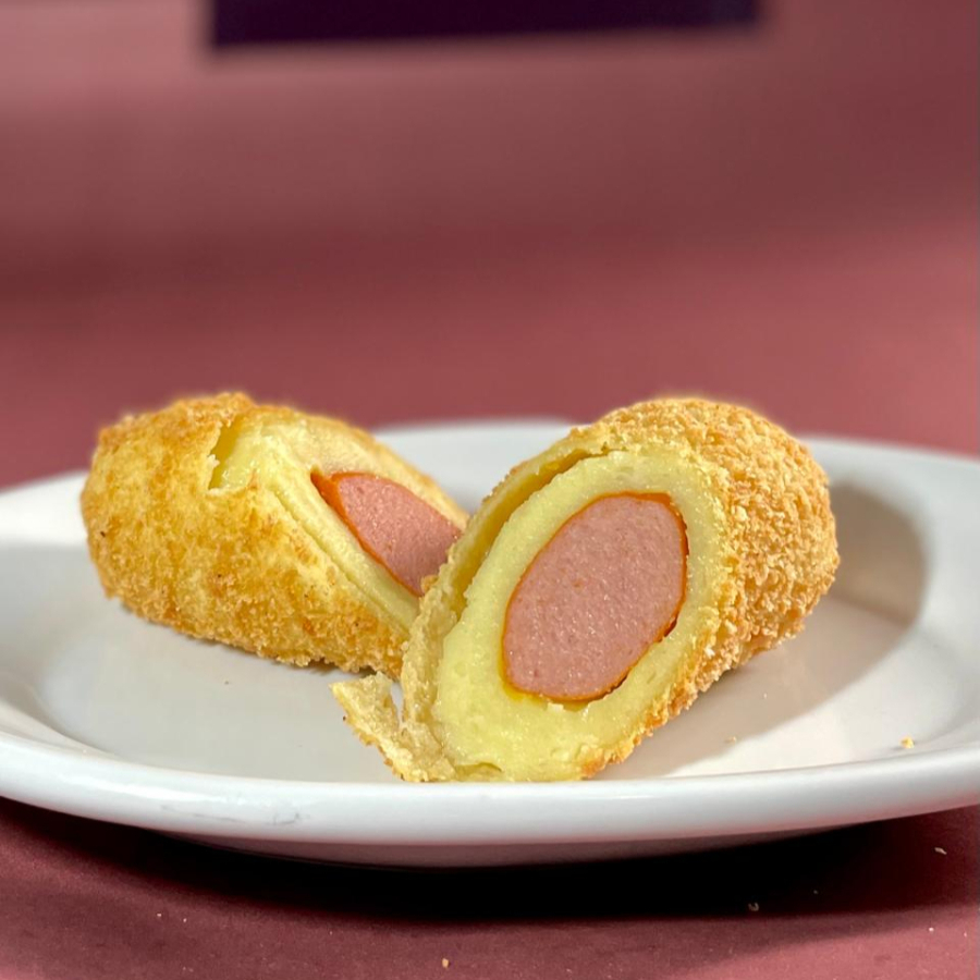 Enroladinho de salsicha 150g, preparado com massa macia de batata, empanado na crocante farinha panko e frito em óleo de palma, garantindo sabor e textura irresistíveis.