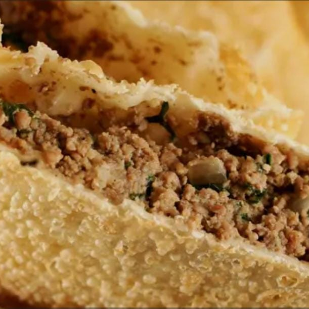 massa crocante sequinha, 15cm, recheada com carne moída temperada.