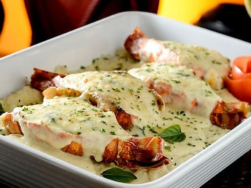 400g de lagosta grelhada, servidas sobre cremoso arroz com manjericão, envolvido com molho branco. Gratinado com queijo mussarela e parmesão. Acompanha batata palha.