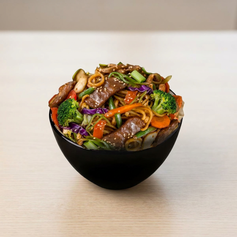 Macarrão salteado no óleo de gergelim, combinado com tiras macias de carne bovina, brócolis frescos, repolho roxo e verde, cenoura crocante e pimentões coloridos. Tudo finalizado com um molho levemente adocicado que realça os sabores e garante uma experiência irresistível.