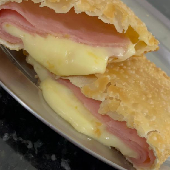 Saboreie o clássico pastel Bauru simples, com recheio de presunto, queijo e tomate, uma combinação irresistível.