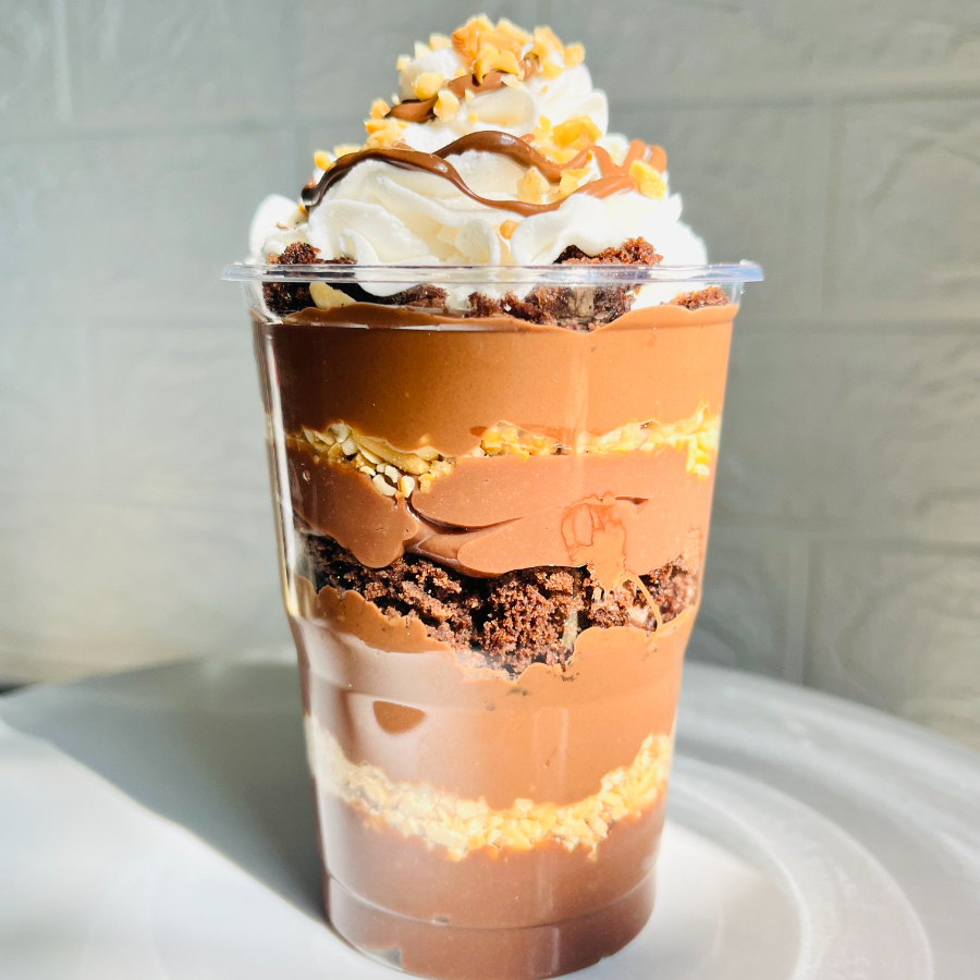 Feito com camadas de recheio de chocolate, amendoim triturado, NUTELLA PURA, brownie, repete as camadas e finaliza com nosso chantininho cremoso e mais NUTELLA e amendoim triturado.