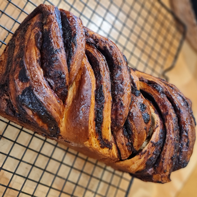 Feita de massa folhada (de croissant), trançada e recheada com nossa pasta de cacau 100% e gotas de chocolate meio amargo. É amanteigada e super recheada! Serve 4 pessoas (450g)