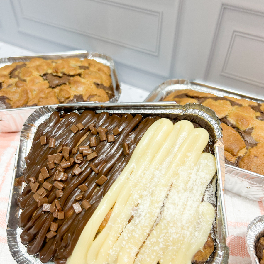Brownie + Cookie = Amor à primeira mordida! Uma combinação perfeita: a maciez do brownie com a crocância do cookie. Massa de cookie tradicional coberto com brownie de chocolate intenso e pedaços de nozes, finalizado com brigadeiro de panela ao leite e brigadeiro de leite ninho e nutella.