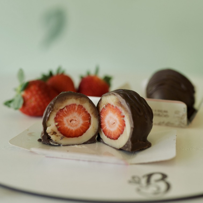 Bombom de morango em volto no brigadeiro de leite Ninho banhado no chocolate meio amargo. Peso apróx. 70g