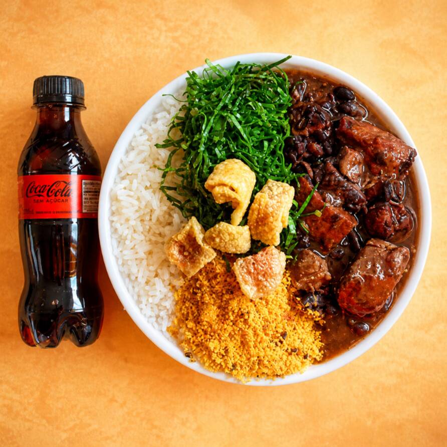 Marmita feijoada magra individual (arroz, costelinha, linguiça calabresa, paio, couve refogado na manteiga, farofa e torresmo). Acompanha refrigerante pet Coca Cola Zero sem açúcar bem gelado. Marmita indicada para 01 pessoa.