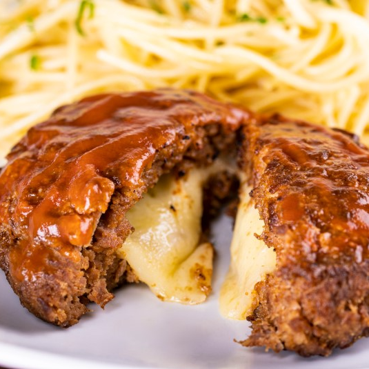 Polpetone de carne. Blend de carne vermelha selecionada com bacon, recheada com queijo mussarela, empanado na farinha panko, coberto com queijo mussarela e um delicioso molho de tomate da casa. Acompanha um espaguete incrivelmente delicioso ao molho pomodoro.