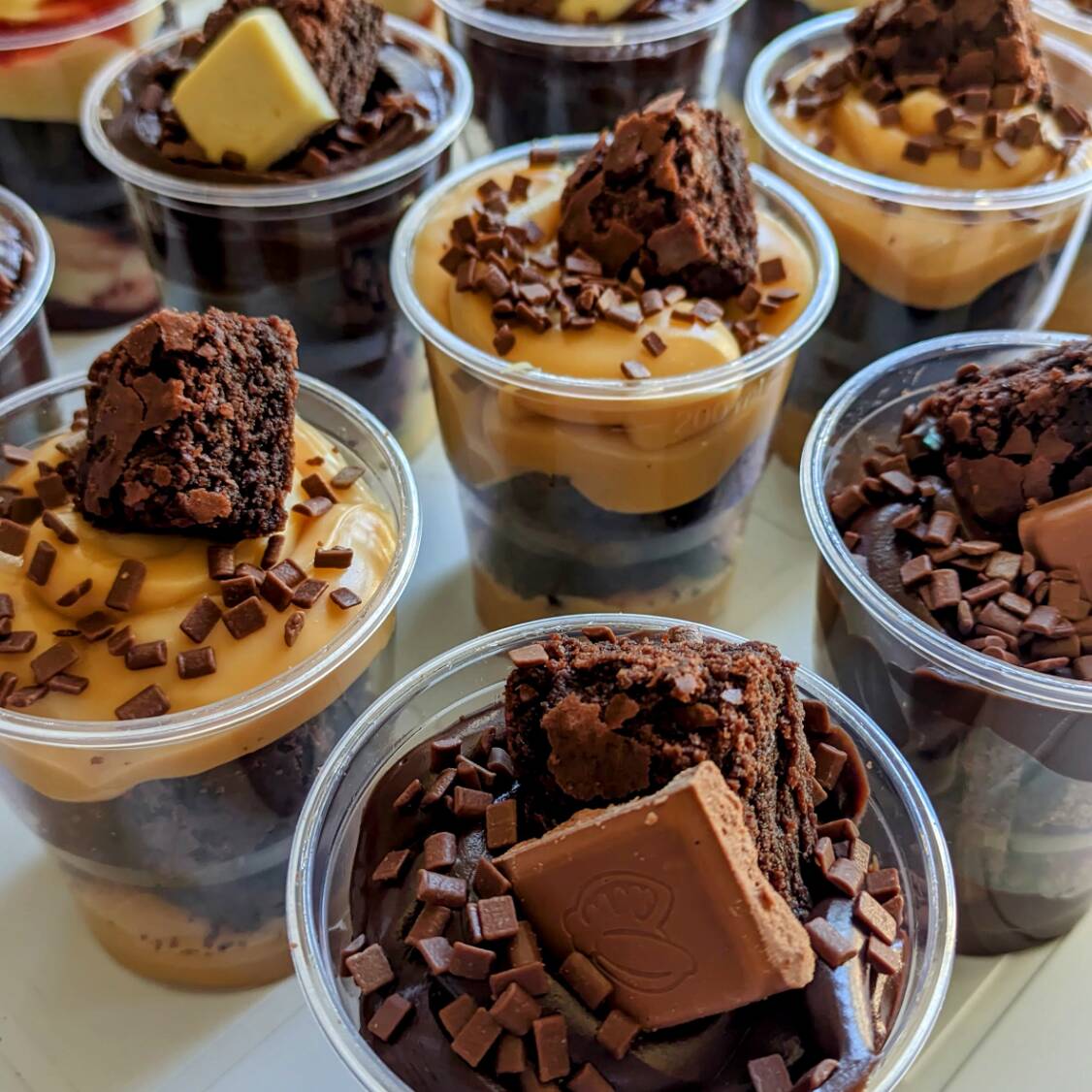 Escolha 2 sabores dos nossos famosos Copos de Brownie (250g cada). A combinação perfeita da nossa massa tradicional com recheios super cremosos e topo crocante. Ideal para dividir (ou não).
