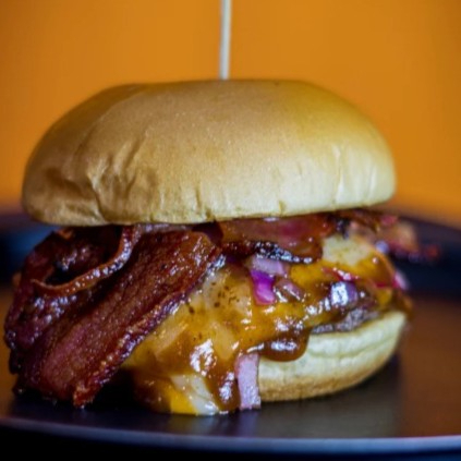 Delicie-se com nosso pão de brioche de 150g, recheado com queijo muçarela, cheddar e bacon em cubos. Completo com um molho especial, cebola roxa caramelizada na manteiga e shoyu, finalizado com o toque do chef e um saboroso barbecue.