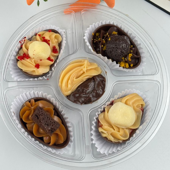 Petisqueira com ovinhos de 50G, com recheios variados. Brownie com doce de leite, ninho com geléia, Red velvet, Cenoura com chocolate. 4 Sabores para saborear mas, no meio um pequeno recheio de ninho e chocolate.