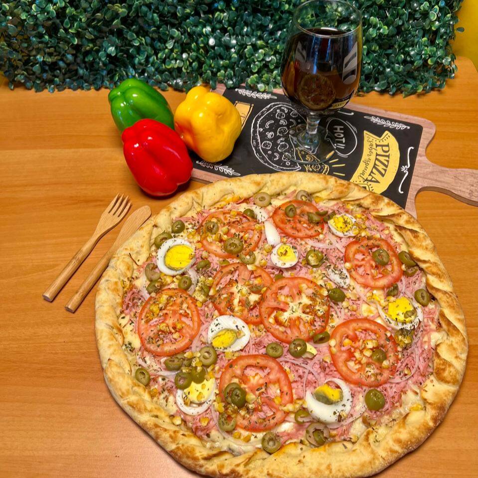 Massa, molho de tomate, muçarela, presunto, ovos, ervilha, azeitona verde, tomate, cebola e orégano. Média 30cm