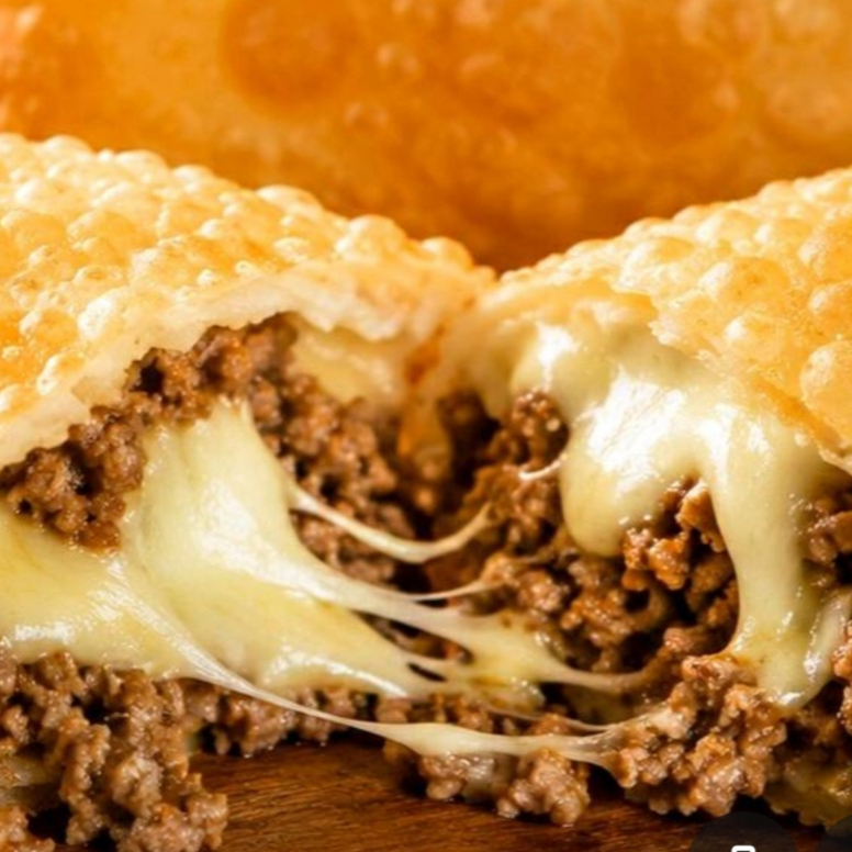 O clássico nunca sai de moda! Massa fina, leve e extremamente crocante, frita na medida certa até ficar dourada e sequinha. Recheio suculento de carne moída bem temperada, refogada com cebola, alho , salsinha, queijo tipo mussarela e um toque especial que realça ainda mais o sabor.