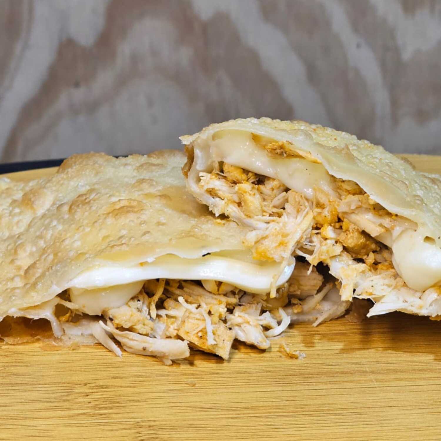 Delicioso pastel recheado com frango desfiado e catupiry cremoso. Uma combinação irresistível de sabores em cada mordida.