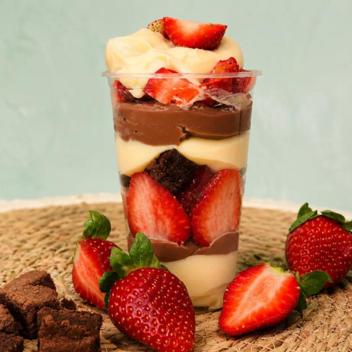 Um delicioso copo da felicidade recheado com leite ninho, chocolate, morango e brownie!