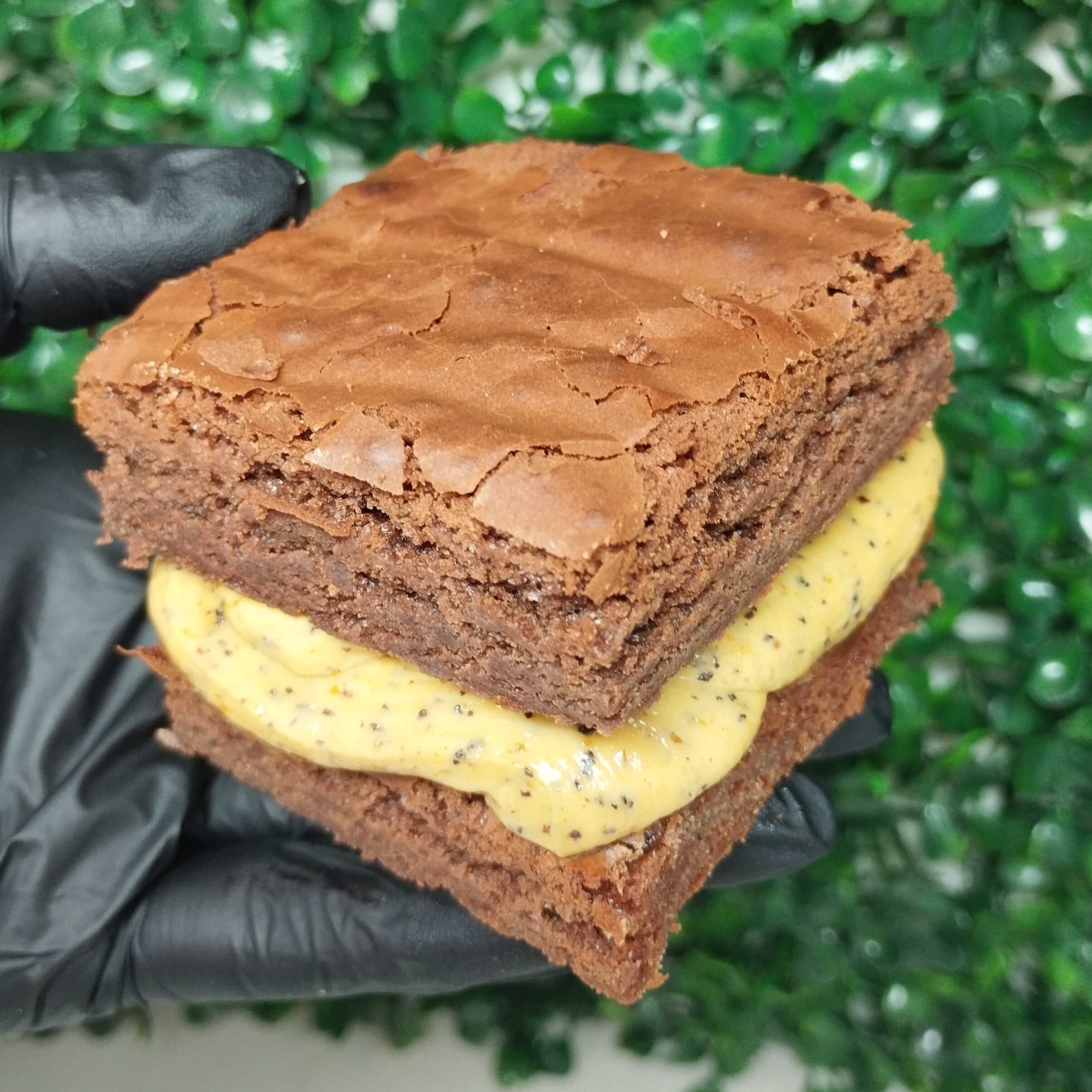 Brownie artesanal macio com recheio cremoso de maracujá, combinando chocolate intenso com um toque cítrico delicioso!
