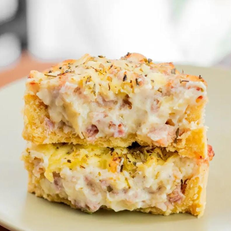 Empada aberta de massa amanteigada, com recheio cremoso e pedaços de bacon.