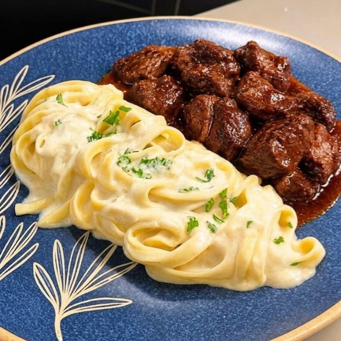 Cubos de lagarto bovino assados lentamente, dourados por fora e macios por dentro, envolvidos em um intenso e saboroso molho demi-glace. Acompanha fettuccine envolvido em um molho branco cremoso, finalizado com ervas frescas.