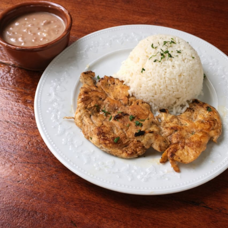 filé de frango grelhado no ponto certo, acompanha arroz branco fresquinho e feião caseiro trazendo sabor e equili brio para seu almoço