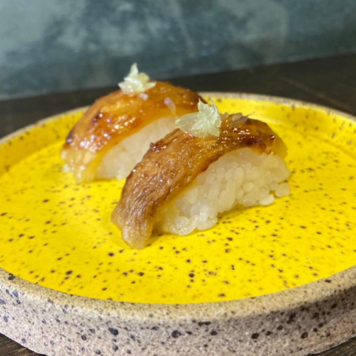 Berinjela defumada artesanalmente, servida sobre arroz com melado e missô e um toque cítrico de limão.