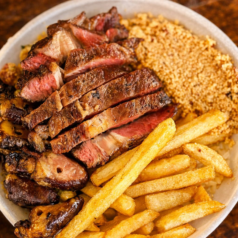 Arroz, feijão tropeiro, farofa, batata frita e vinagrete.