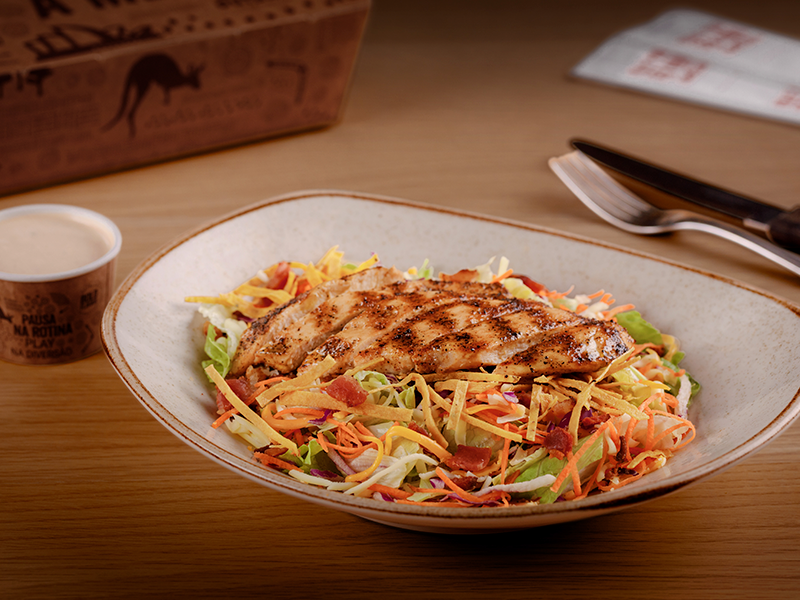 Peito de frango grelhado e macio sobre uma combinação de alface, cenoura, repolho roxo, mix de queijos, bacon e tiras de tortillas crocantes. Com o exclusivo molho barbecue ranch.