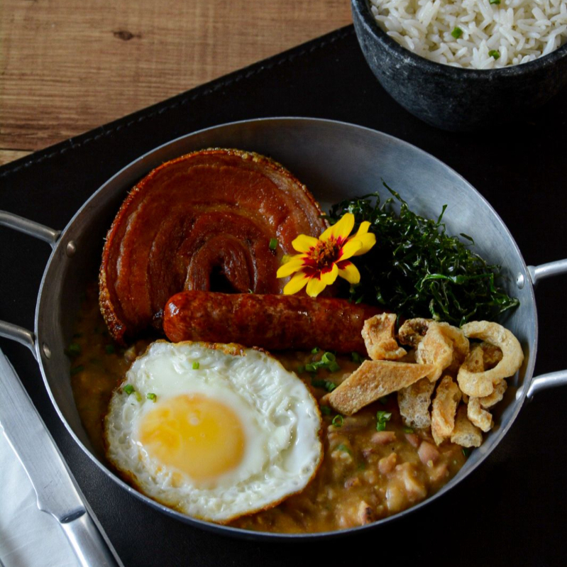 Panceta de rolo, linguiça pura, ovo frito, arroz, tutu de feijão com torresmo e crocante de couve.