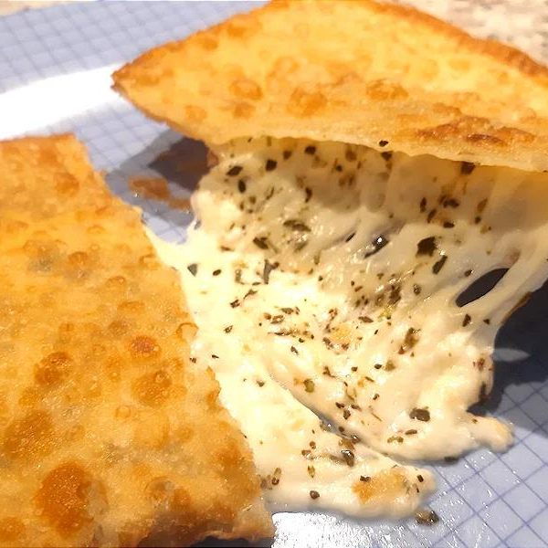 Pastel crocante com recheio de queijo derretido.