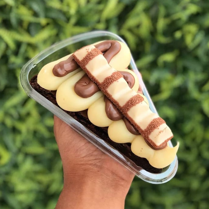 Brownie super macio e chocolatudo, coberto com creme de Ninho, Nutella cremosa e pedaços de Kinder Bueno para finalizar.